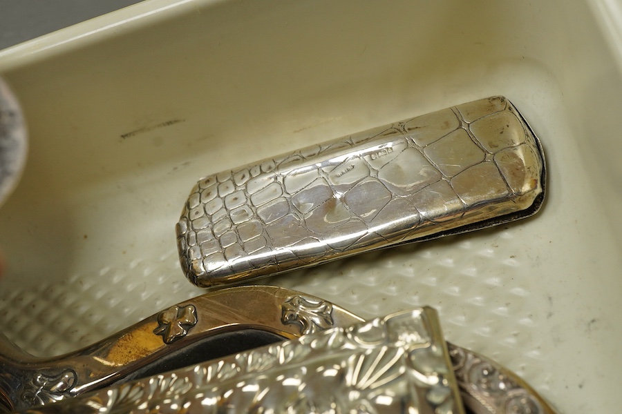 A small group of silver and white metal items, including an Edwardian silver and tortoiseshell mounted hand mirror by Samuel Jacob, 26.1cm, a silver mounted hair brush, a small silver mounted brush, a repousse silver pin